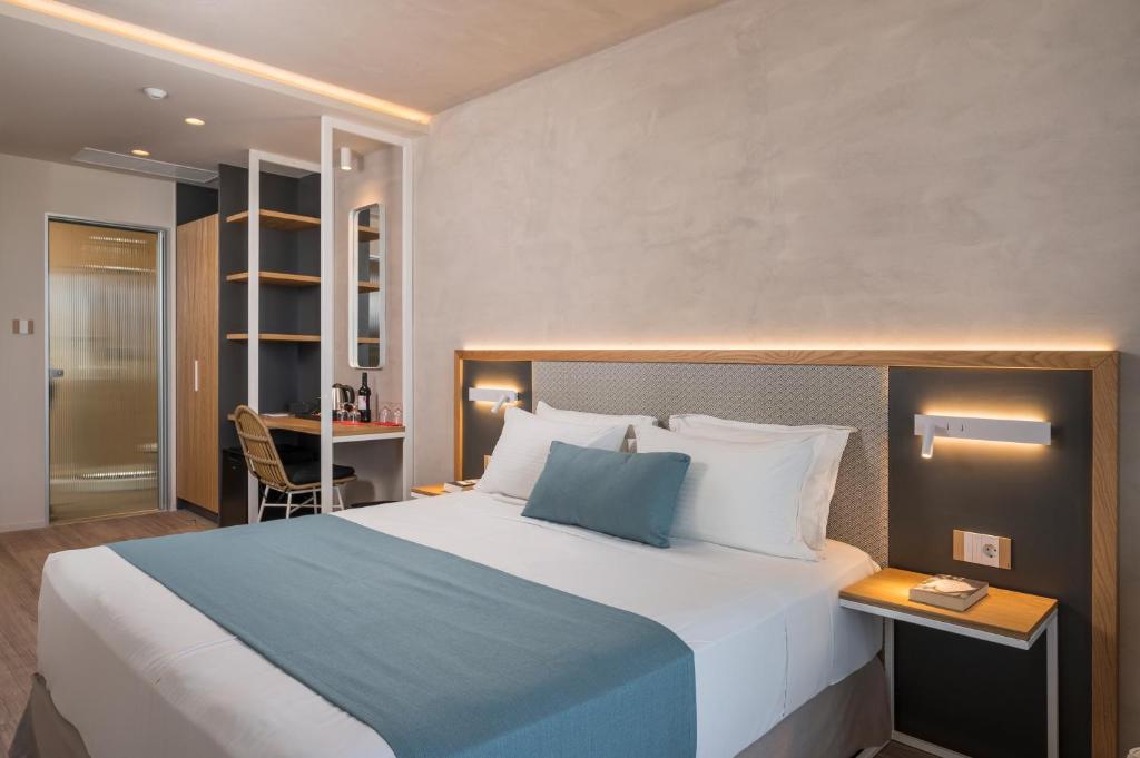 Mūsdienīga viesnīcas numura iekārtojums ar plašu gultu, darba galdu un elegantu apgaismojumu. Interjers apvieno komfortu un stilīgu dizainu.