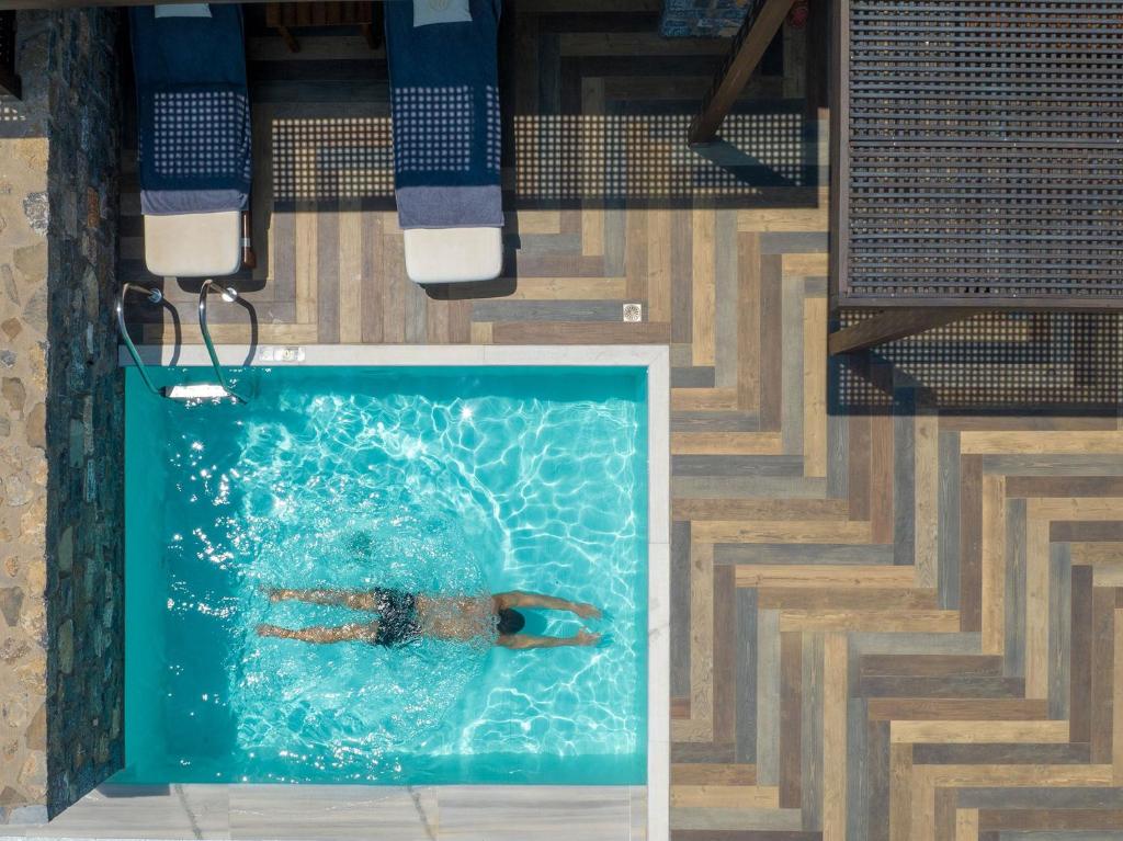 Vīrietis peld baseinā Royal Marmin Bay Boutique & Art Hotel