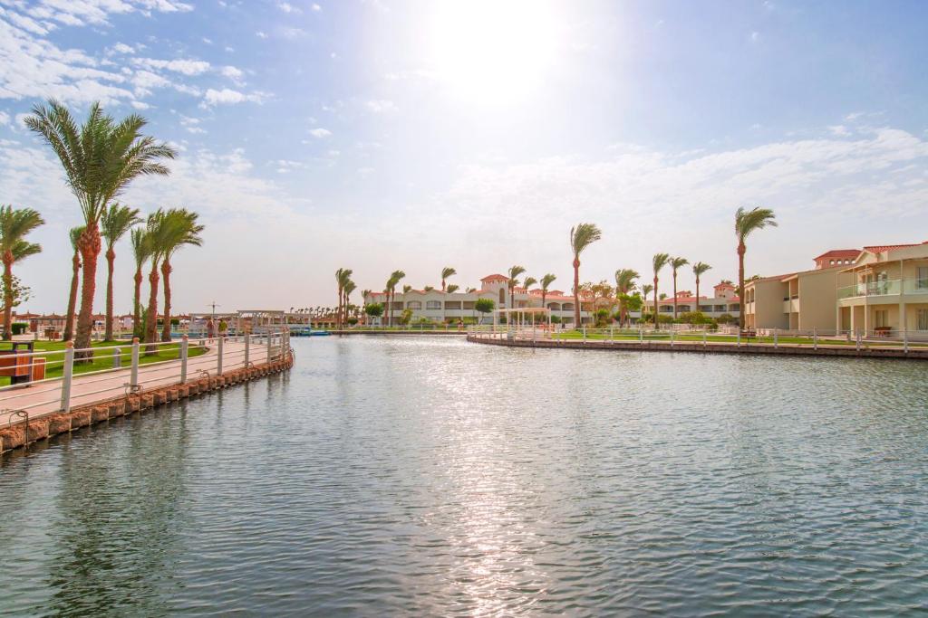 Skats uz Pickalbatros Dana Beach Resort piekrastē ar palmām un laivu piestātni.