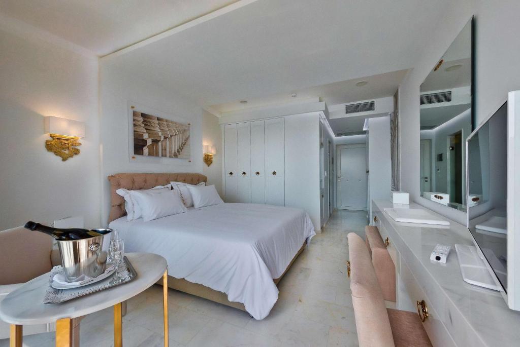 Mūsdienīgs numurs Royal Marmin Bay Boutique & Art Hotel ar gultu un televizoru.