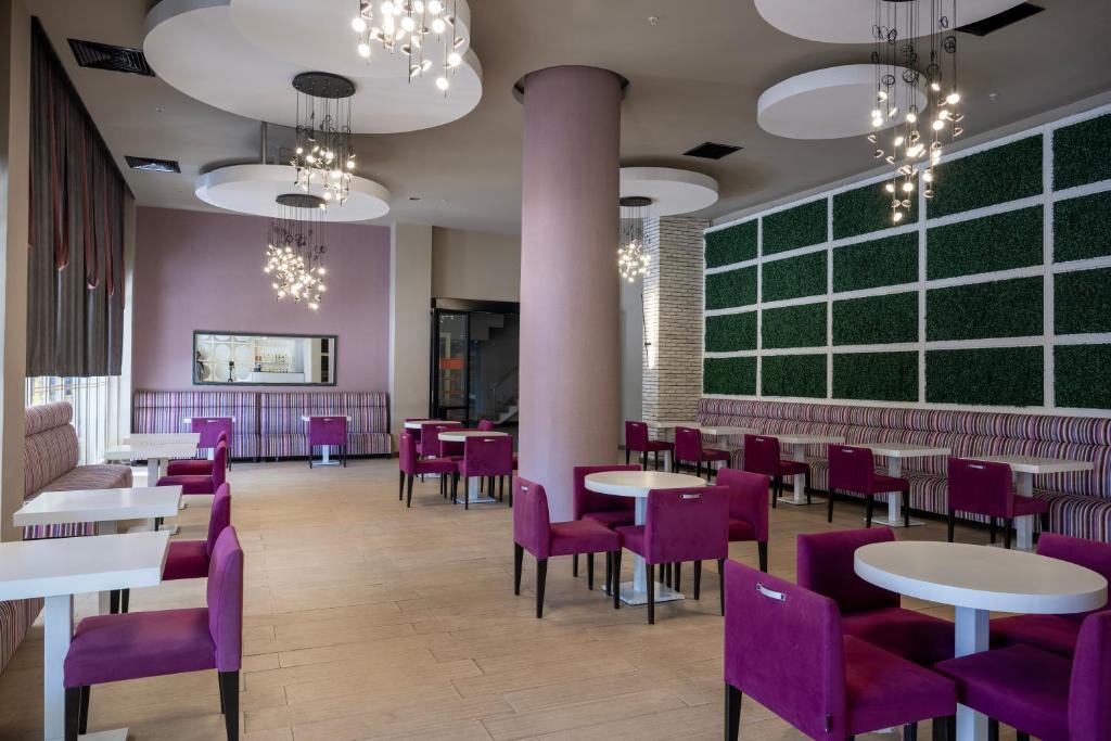 Moderns bārs L'oceanica Beach Resort Hotel ar rozā un baltu interjeru.