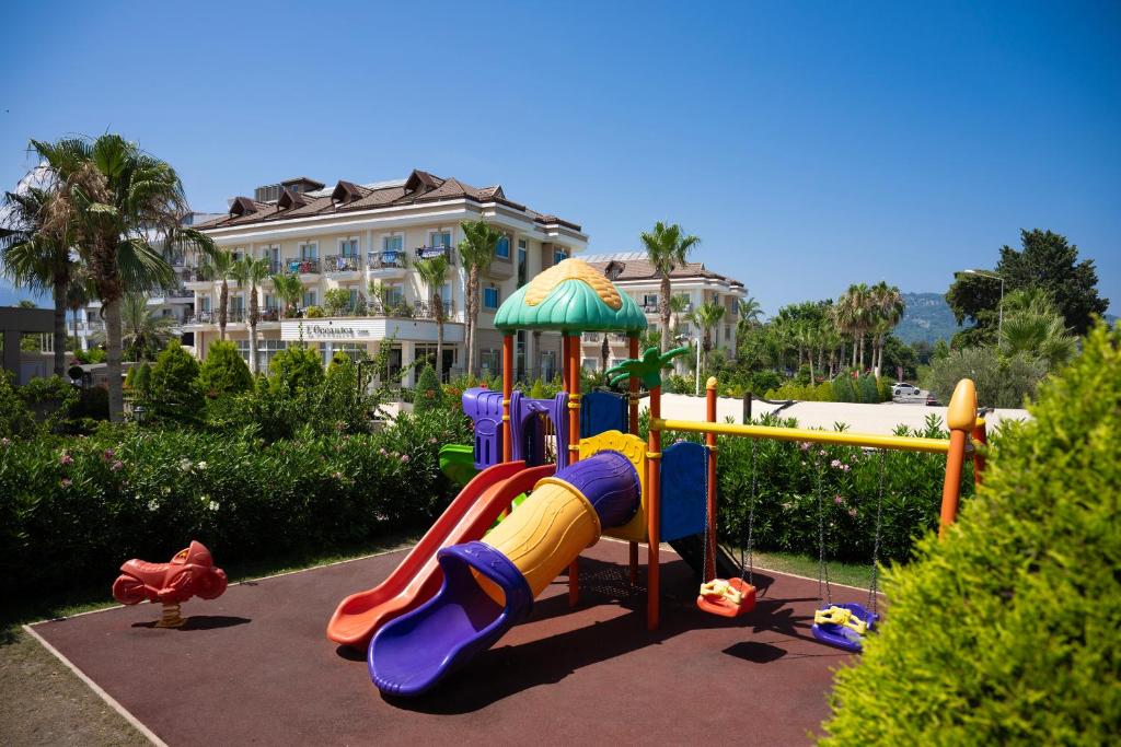 Bērnu spēļu laukums L'oceanica Beach Resort Hotel ar slaidu un šūpolēm.