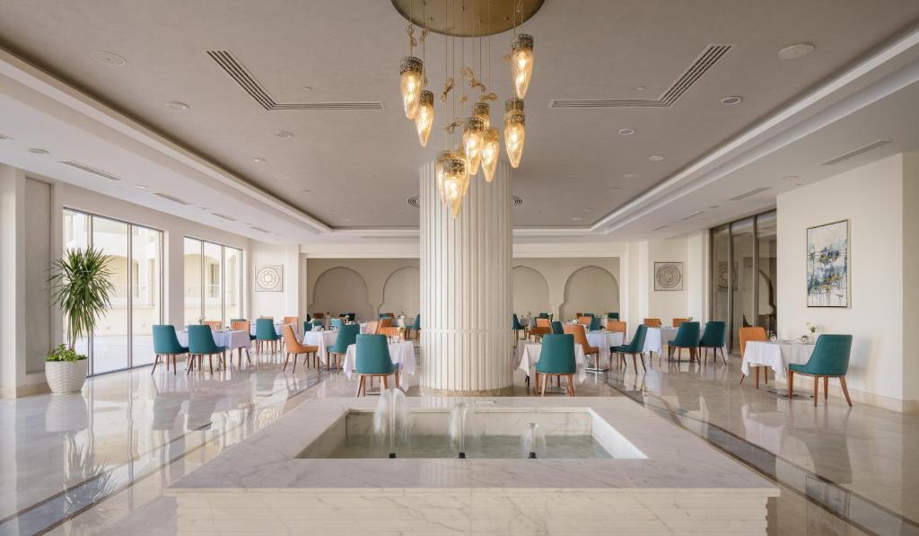 Mūsdienīgs restorāns Xanadu Makadi Bay ar elegantiem galdiem un apgaismojumu.