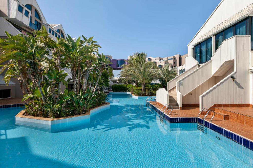 Susesi Luxury Resort peldbaseins ar tropu augiem un saulainām terasēm.