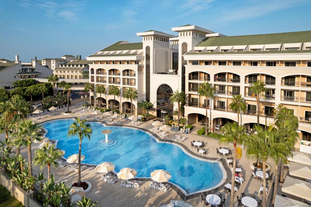 Dobedan Exclusive Hotel & Spa pie baseina ar palmām un saulessargiem