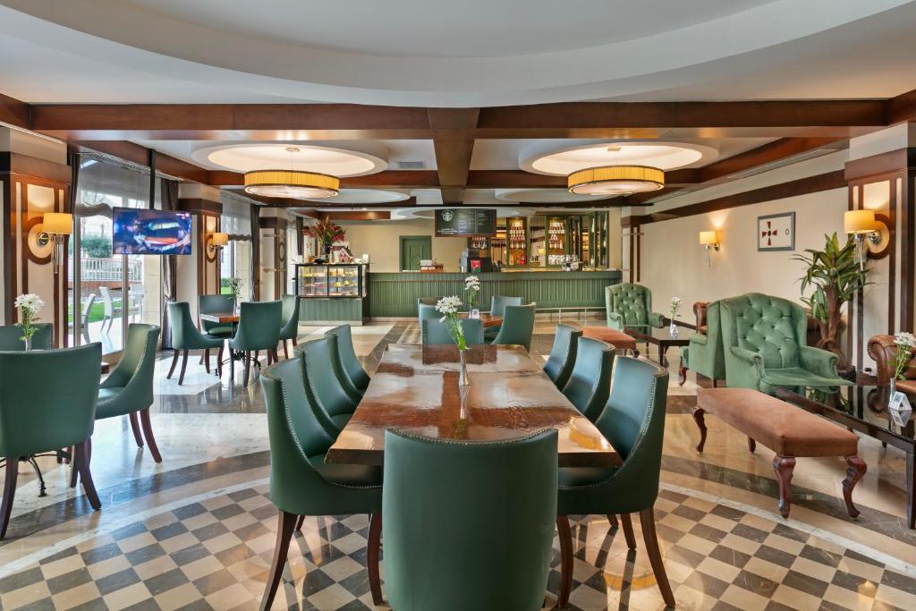 Eleganta atpūtas zona Dobedan Exclusive Hotel & Spa ar zaļām mēbelēm.