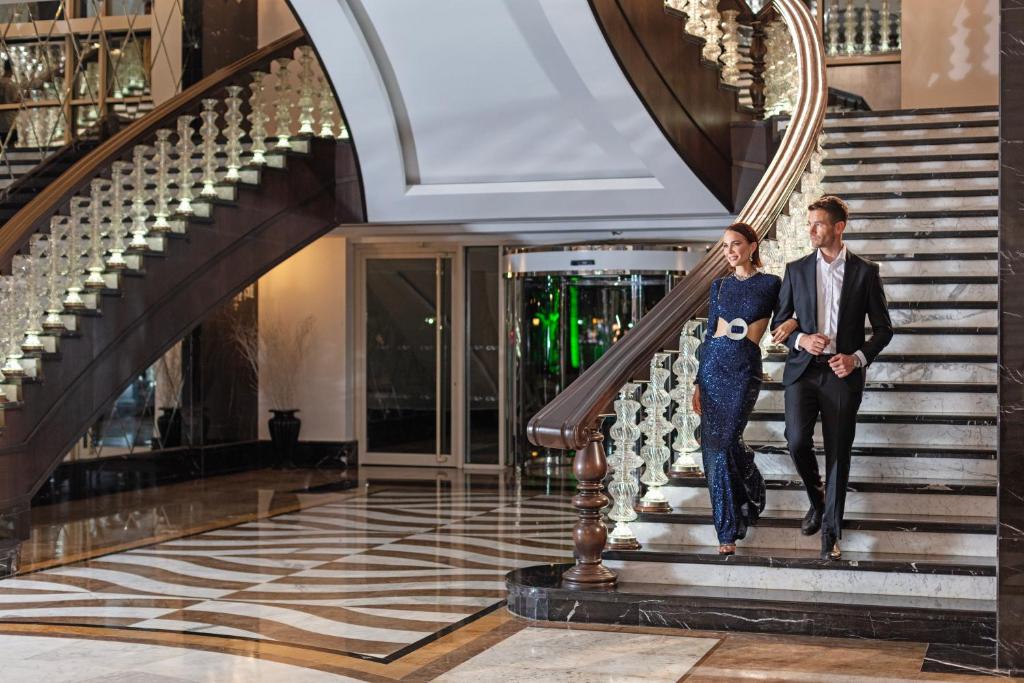 Eleganti pāris kāpj pa greznām kāpnēm Dobedan Exclusive Hotel & Spa