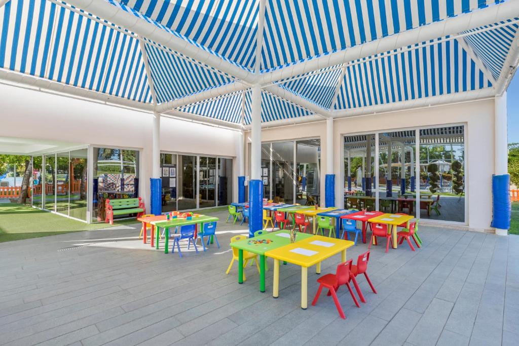 Bērnu rotaļu laukums Dobedan Exclusive Hotel & Spa ar krāsainām galdiņām un nojumi.