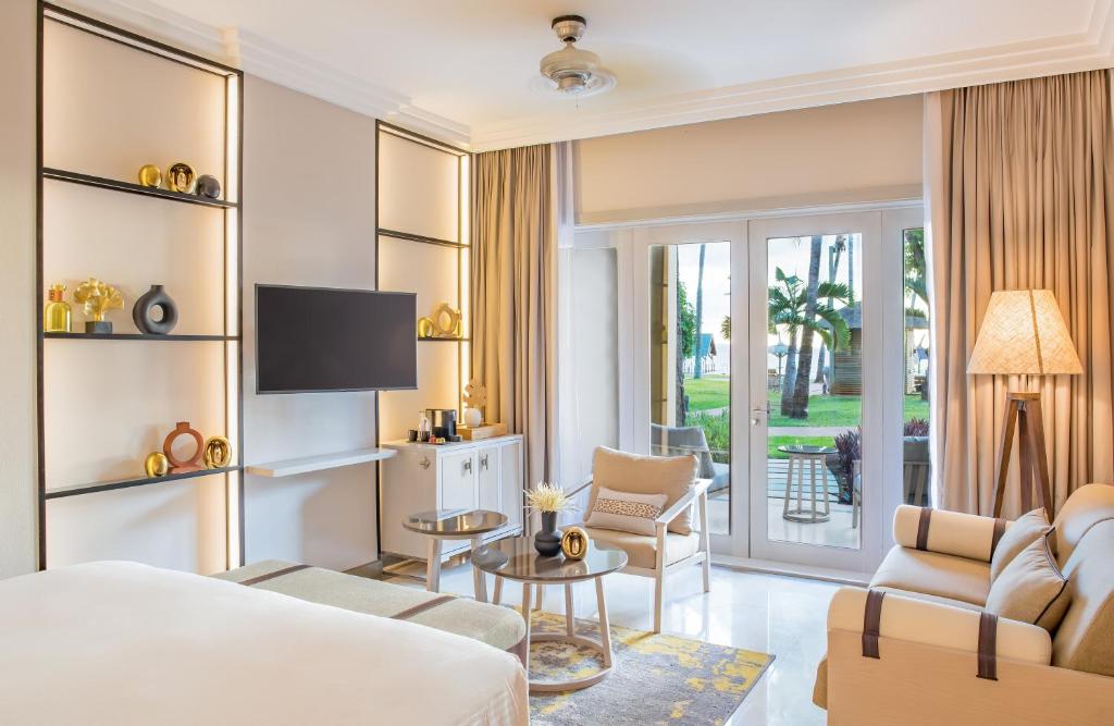 Mūsdienīgs viesnīcas numurs ar elegantu interjeru, kas ietver televizoru, atpūtas stūri un plašus logus ar skatu uz āra terasi un dārzu. Ideāla vieta relaksācijai un atpūtai.