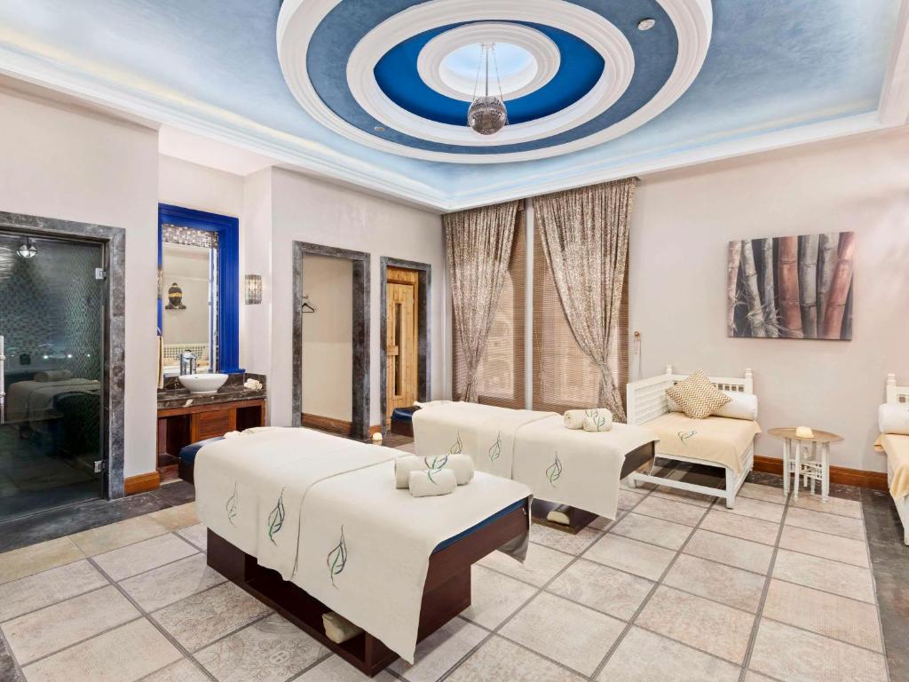 Spa telpa ar divām masāžas gultām un relaksējošu interjeru, kas ietver elegantus apgaismojumus un dekoratīvus elementus. Ideāla vide relaksācijai un atpūtai.
