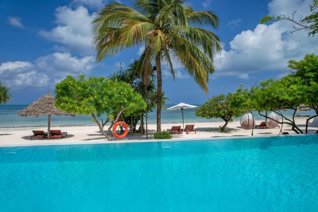 Alma Boutique Hotel pludmale ar baseinu un palmu kokiem