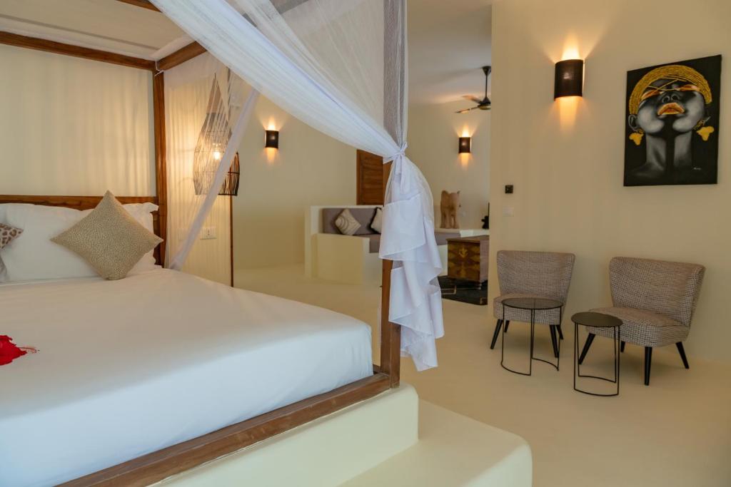 Alma Boutique Hotel luksusa numurs ar mākslas darbiem un sēdvietu zonu.