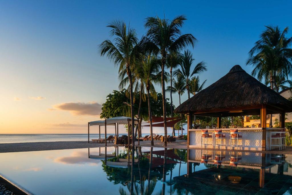 Hilton Mauritius Resort & Spa piekrastes bārs ar skatu uz saulrietu.