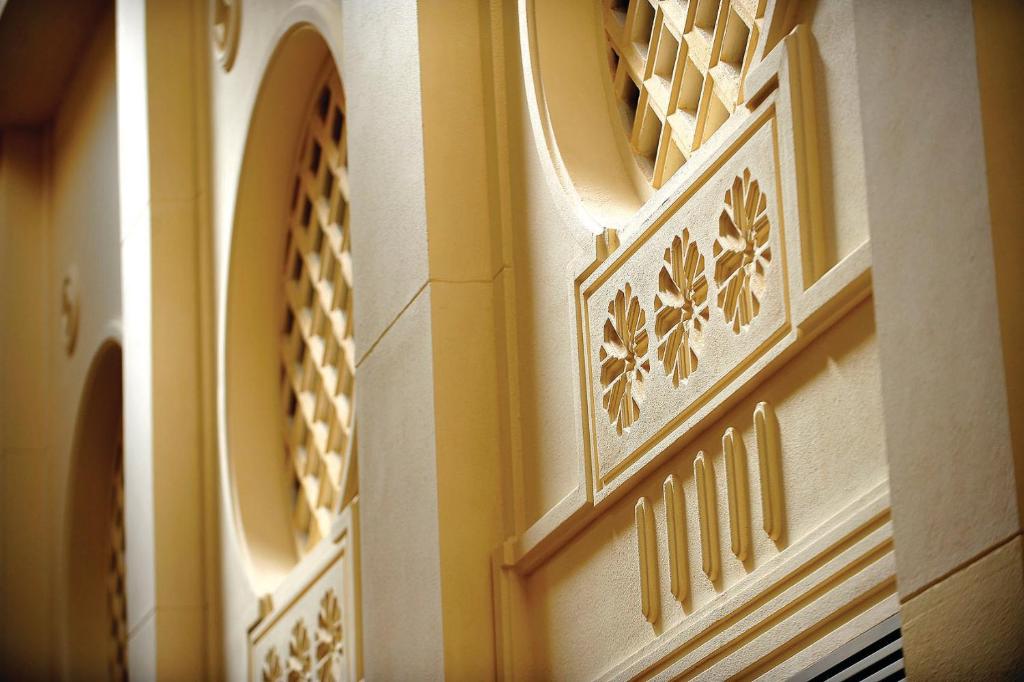 Sienas dekoratīvie elementi ar izteiksmīgām reljefām formām un tekstūrām, radot elegantu arhitektūras stilu.