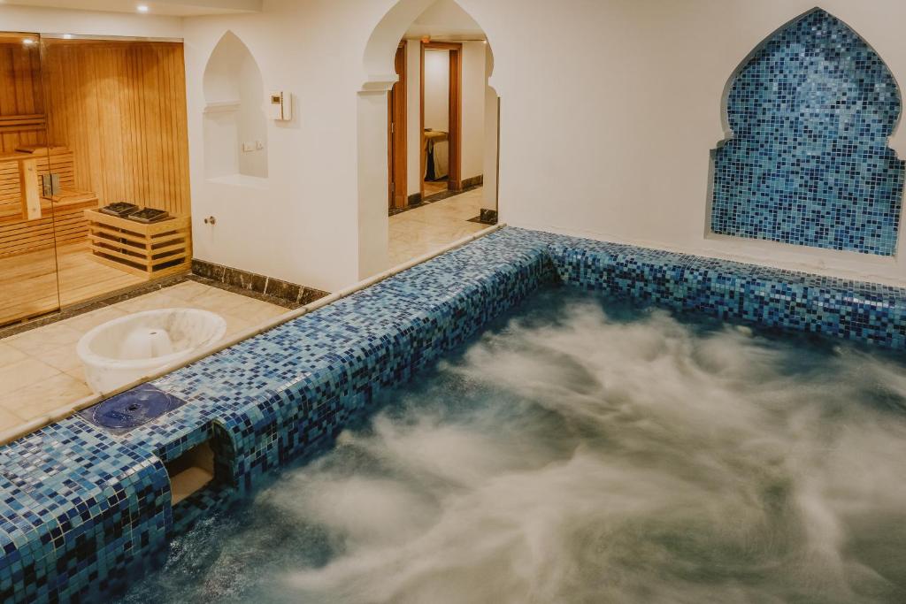 Relaksējoša spa vide ar zilu mozaīkas baseinu un koka saunu. Ideāla vieta atpūtai un labsajūtai.