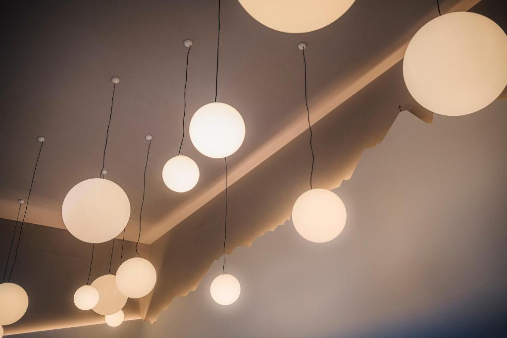 Mūsdienīgu gaismas ķermeņu kolekcija, kas sastāv no dažāda izmēra apaļām lampām, karājoties no griestiem. Elegantā apgaismojuma dizains piešķir telpai stilīgu atmosfēru.