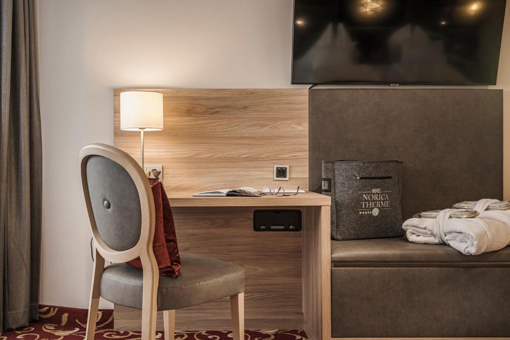 Mūsdienīgs viesnīcas numurs ar elegantu rakstāmgaldu, krēslu un televizoru. Interjerā ir siltas krāsas un komfortabli elementi, piemēram, dvieļi un somiņa.