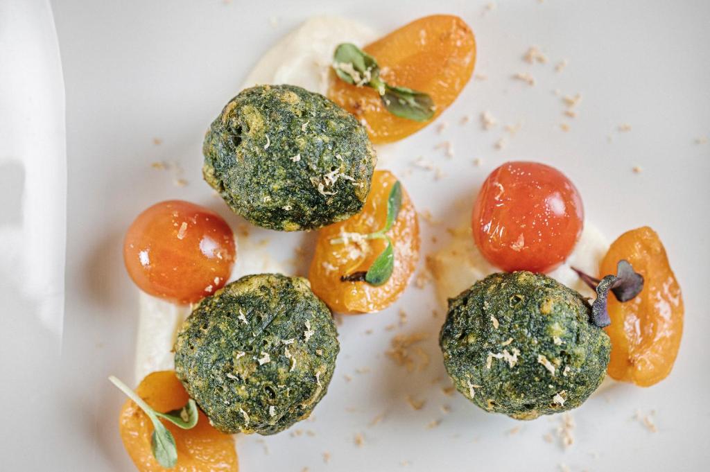 Zaļie ikri ar tomātiem un aprikozēm uz krēmveida mērces. Elegants un krāsains ēdiens, kas izceļ dārzeņu garšas.