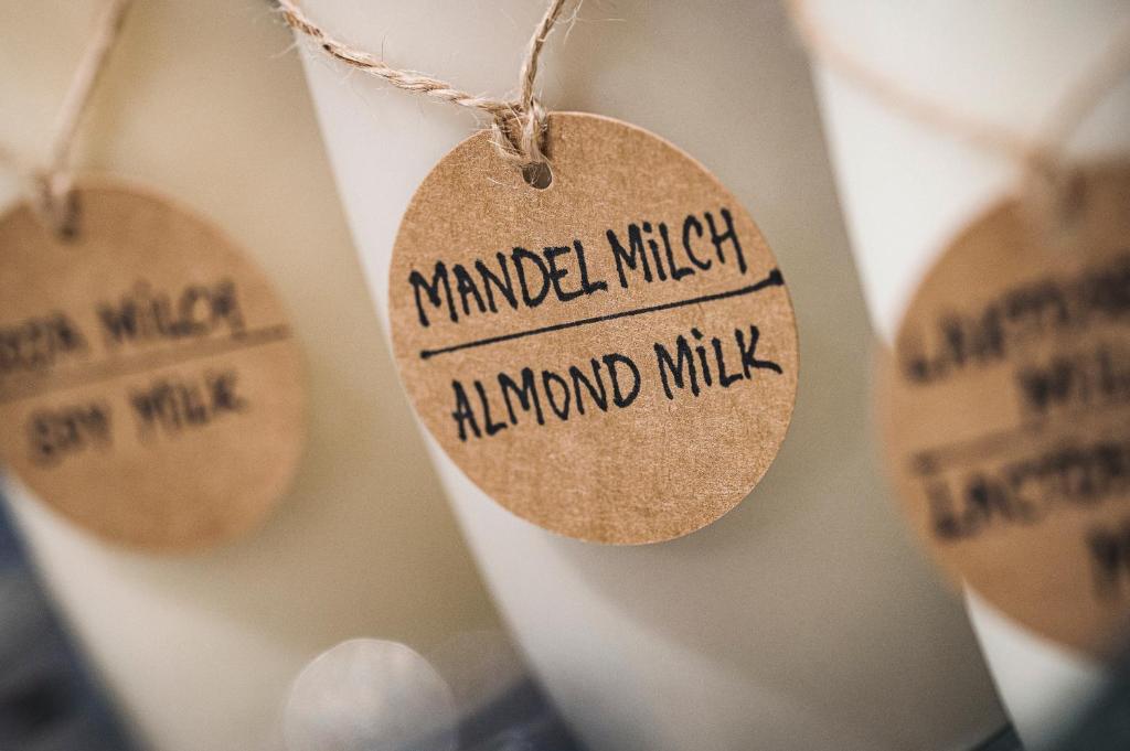 Almonda piena pudeles ar papīra etiķetēm, uz kurām rakstīts "Mandel Milch" un "Almond Milk".