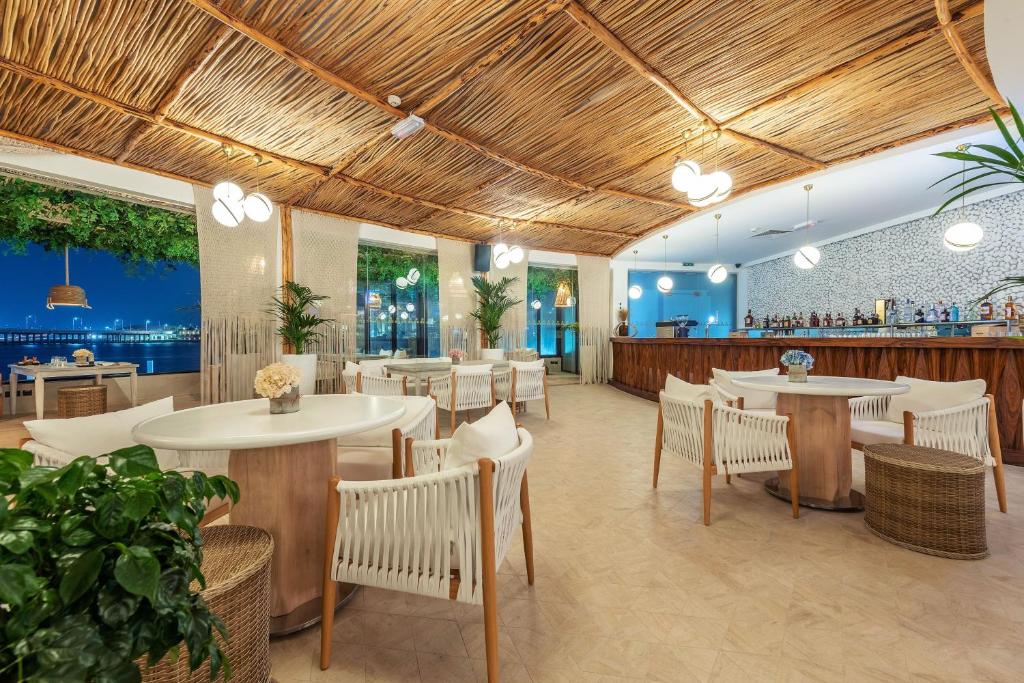 Moderns restorāns ar koka siju griestiem un elegantu interjeru, kas piedāvā skatu uz ūdeni. Ērtas krēsli un apaļi galdi rada patīkamu atmosfēru, ideālu vakariņām vai dzērieniem.