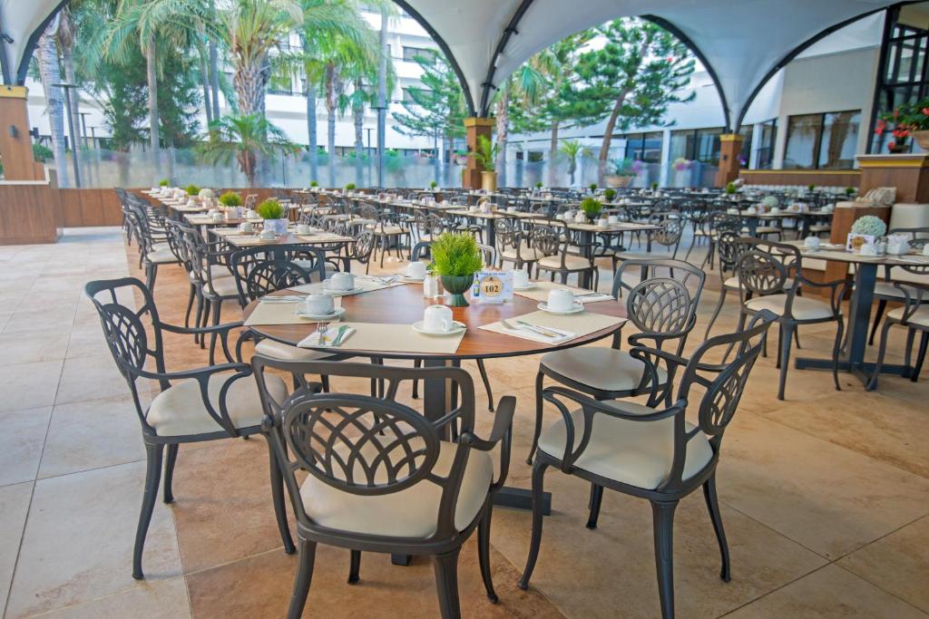 Adams Beach restorāna āra terase ar galdiem un krēsliem.