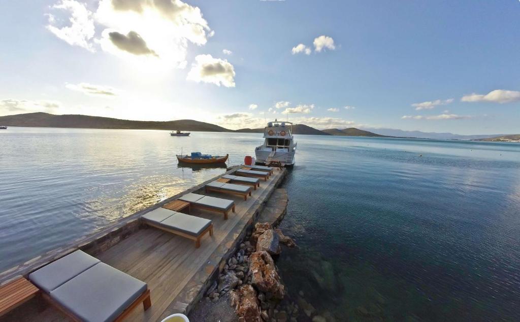 Royal Marmin Bay Boutique & Art Hotel piestātne ar sauļošanās krēsliem piekrastē