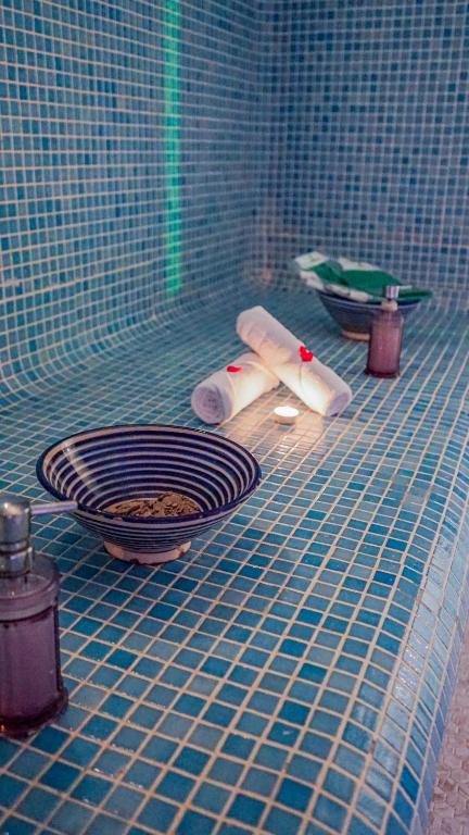 Relaksējoša tvaika pirts skats ar flīzēm, kur novietoti aromātiski ēteriskie eļļas un sveces, radot mierīgu atmosfēru.