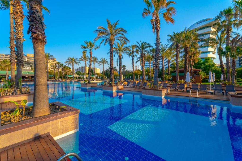 Concorde De Luxe Resort plašais baseins ar palmām un saules krēsliem