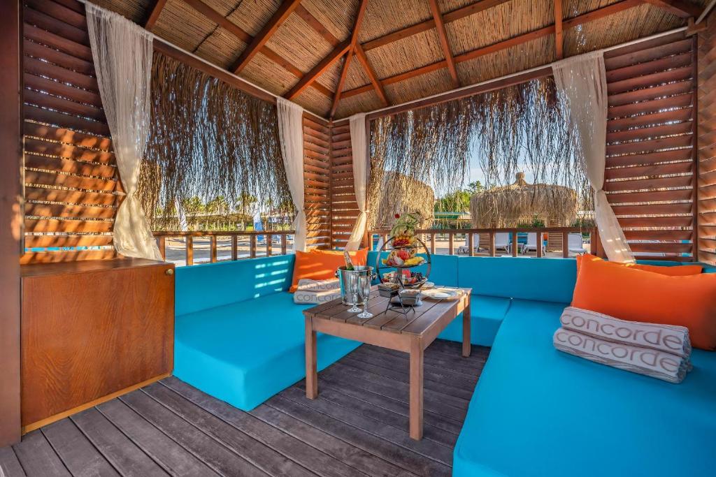 Mierīga atpūtas zona hotelī Concorde De Luxe Resort ar spilveniem un uzkodu galdu.