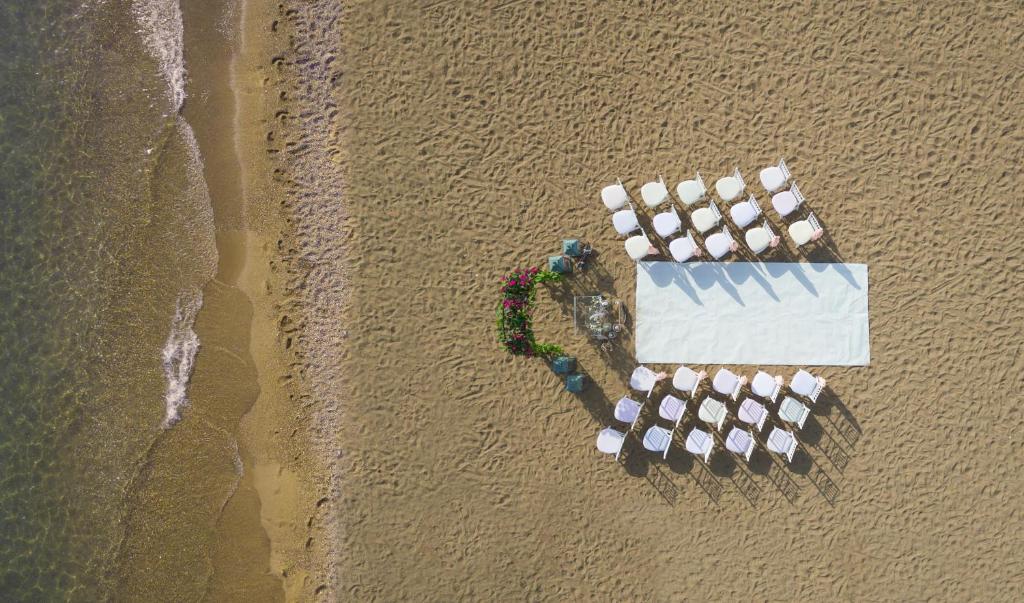 Koncorde De Luxe Resort pludmales kāzu vieta ar galdu un krēsliem