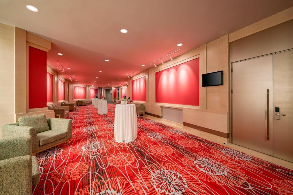 Konferenču telpa Concorde De Luxe Resort ar sarkanu paklāju un komfortablām mēbelēm.