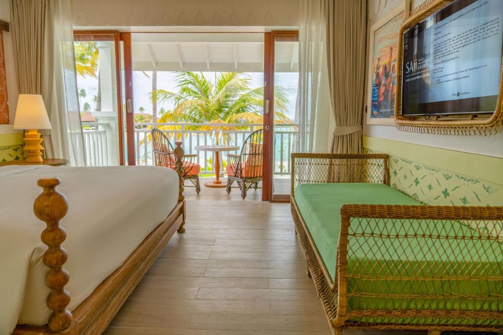 Mūsdienīgs viesnīcas numurs ar skatu uz dārzu, iekārtots ar ērtu gultu, atpūtas krēslu un televizoru. Lieli logi nodrošina dabisku apgaismojumu un piekļuvi terasei.