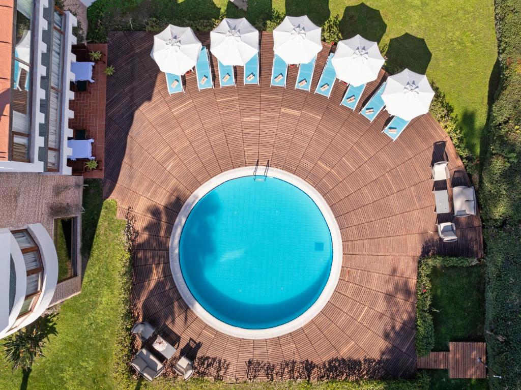 Limak Limra Hotel & Resort peldbaseins ar sauļošanās krēsliem un lietussargiem