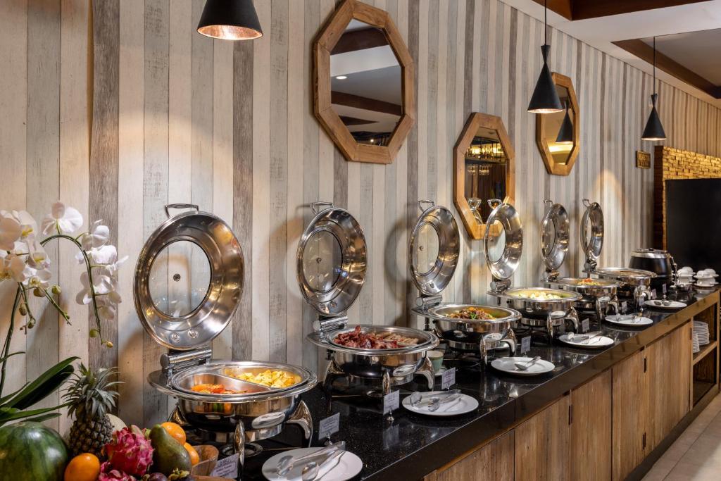 Bagātīgs bufetes galds Taksu Hotel Sanur ar dažādiem ēdieniem.