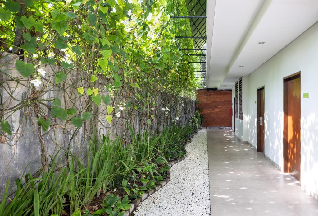 Zaļš balkons Taksu Hotel Sanur ar ziediem un akmens ceļu