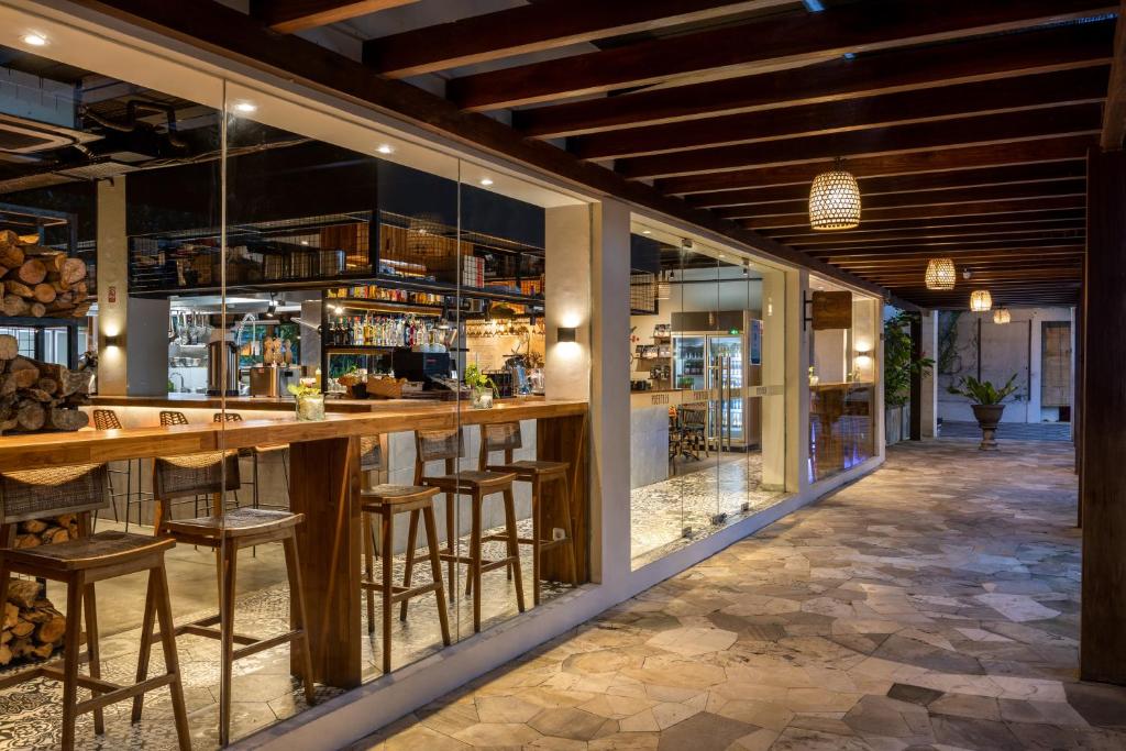 Taksu Hotel Sanur bārs ar koka letēm un mūsdienīgu dizainu