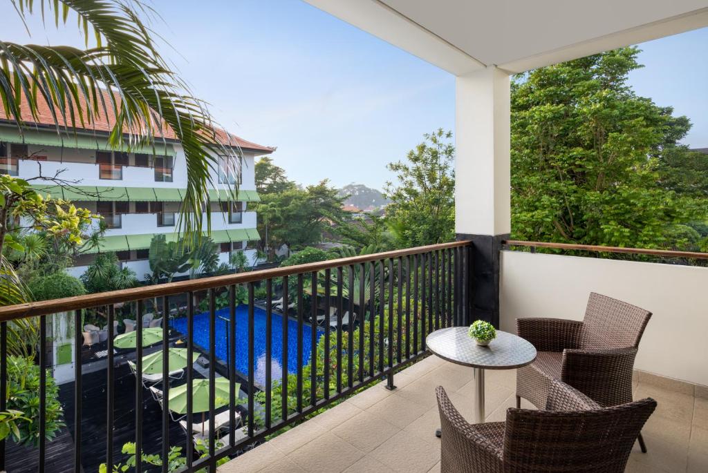 Skats no balkona uz Taksu viesnīcas peldbaseinu un dārzu.