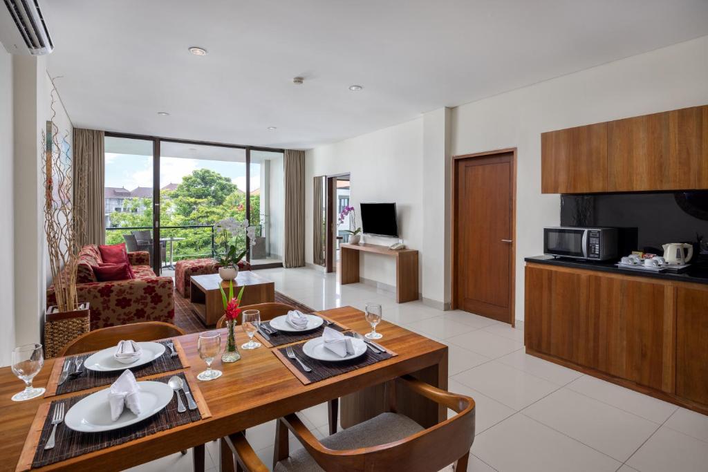 Taksu Hotel Sanur viesnīcas numurs ar dzīvojamo zonu un balkonu.