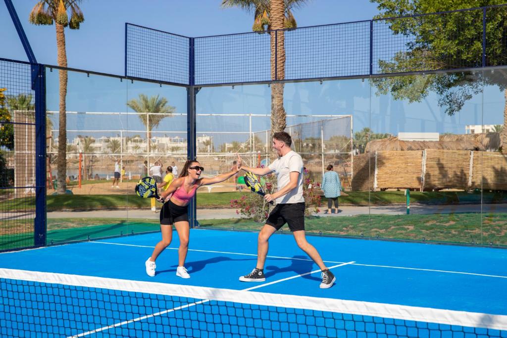 Desert Rose Resort viesi spēlē padel tenisu saulainā laukumā