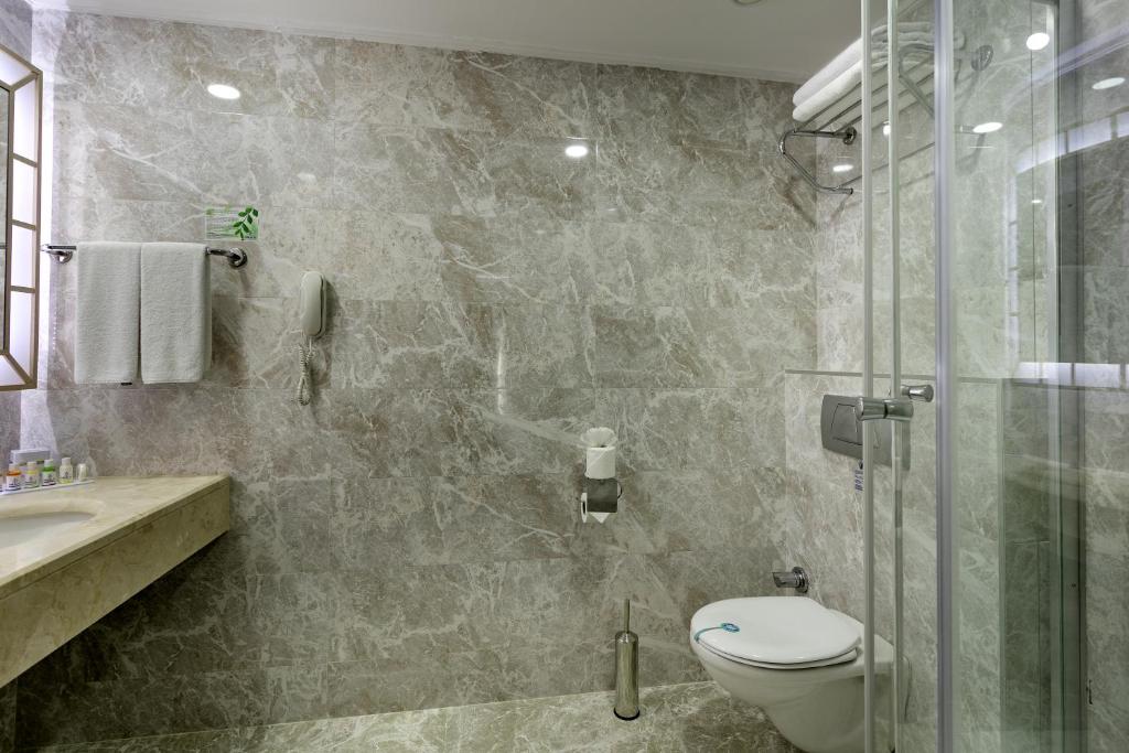 Marmora vannas istaba ar dušu un modernām iekārtām viesnīcā Miracle Resort Hotel