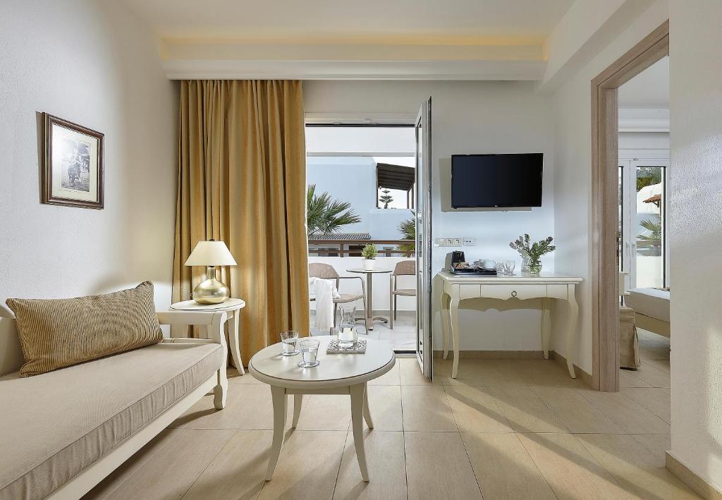 Mūsdienīgs numurs Alexander Beach Hotel & Village ar viesistabu un terasi.