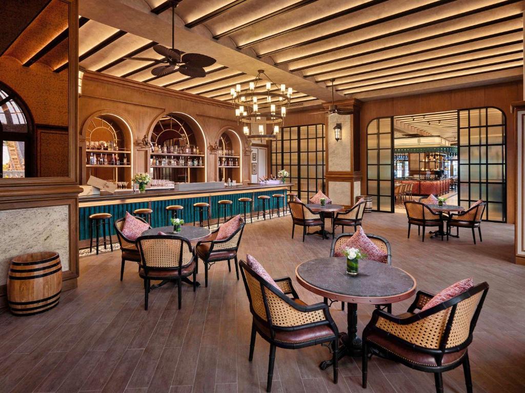 Elegants iekštelpu bārs ar koka grīdu, stilīgu apgaismojumu un komfortablām sēdvietām. Bāra plaukti ir piepildīti ar dzērieniem, radot patīkamu atmosfēru relaksācijai.