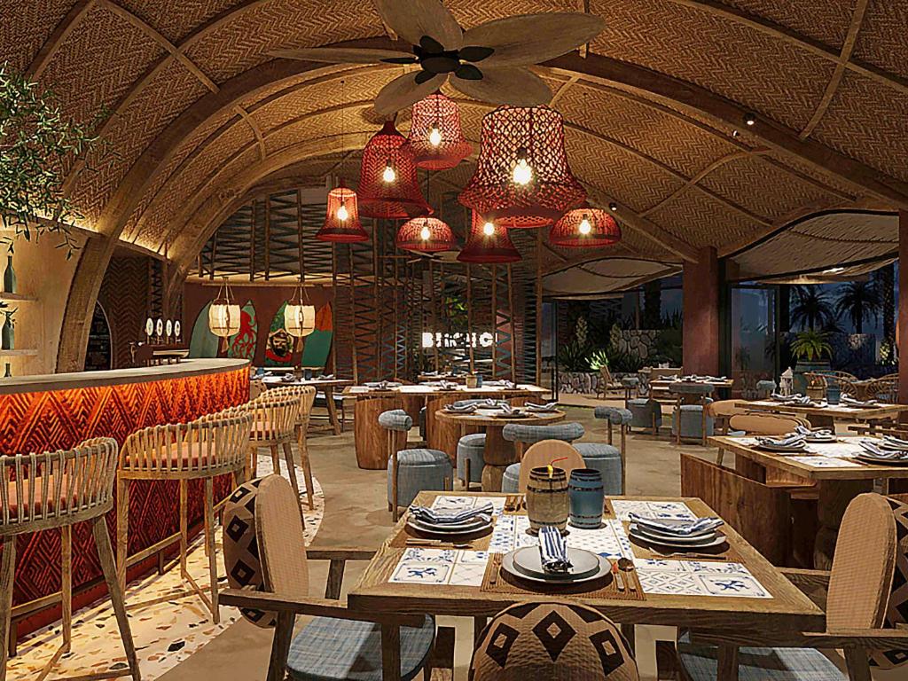 Mūsdienīgs restorāns ar siltu atmosfēru, kurā ir eleganta koka mēbeles un dekoratīvi gaismas ķermeņi. Plašs skats uz dabu caur lieliem logiem, radot relaksējošu vidi.