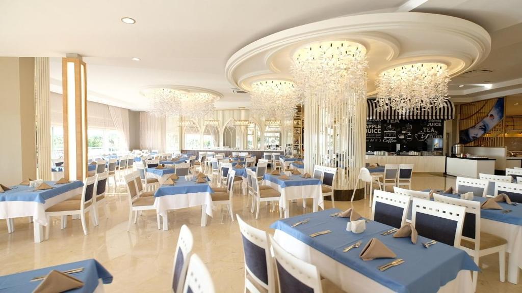 Elegantā restorāna interjers ar zilu galda klājumu Seaden Sea World Resort & Spa.