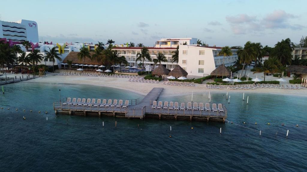 Cancun Bay Resort pludmale ar sauļošanās krēsliem un koka piestātne piekrastē