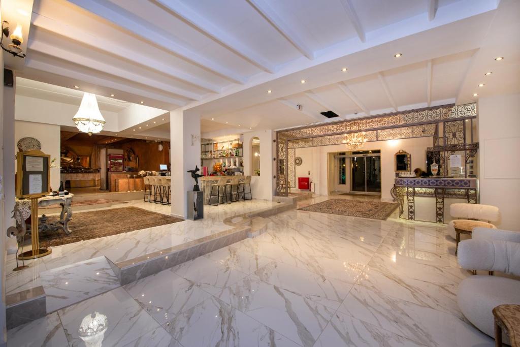 Mūsdienīga viesnīcas uzgaidāmā telpa ar elegantām dekorācijām un marmora grīdu, kurā ir bārs un reģistratūra. Apgaismojums un interjers rada viesmīlīgu atmosfēru.