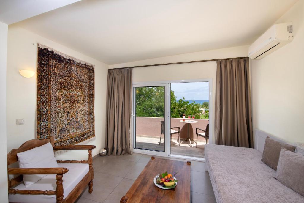 Mūsdienīgs viesnīcas numurs ar ērtu sēdvietu, dabīgu apgaismojumu un skatu uz terasi. Interjerā ir dekoratīvs paklājs un koka mēbeles, kas piešķir siltumu un komfortu.