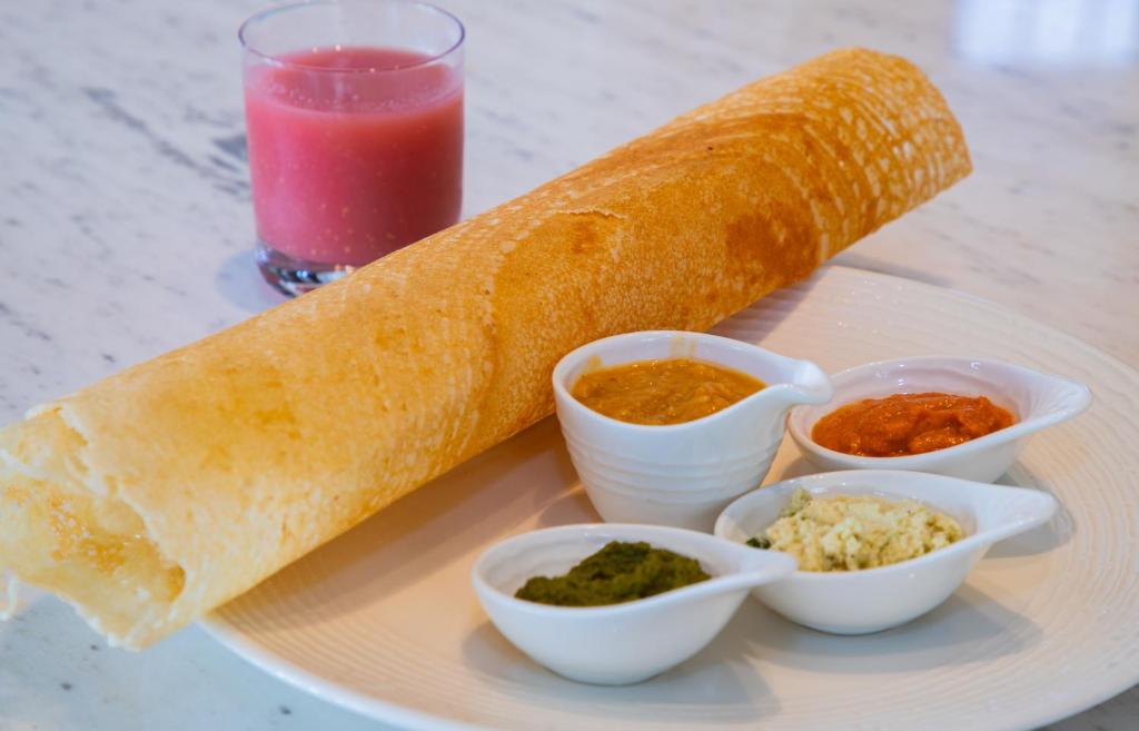 Garšīgs dosha ar četrām dažādām mērcēm un dzērienu blakus. Ideāls Indijas virtuves paraugs.