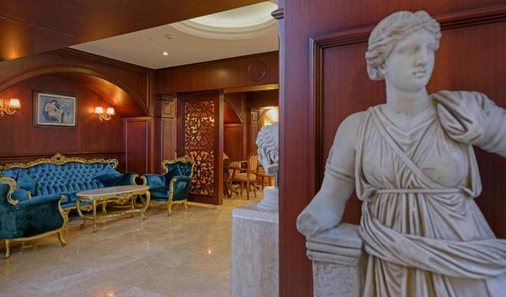 Eleganta viesnīcas Antique Roman Palace interjers ar marmora statuju.