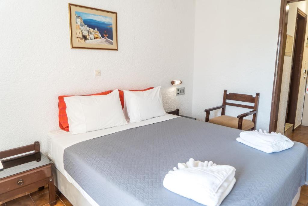 Mūsdienīga guļamistaba ar divguļamo gultu, sarkanām spilvendrānām un vienkāršu koka mēbeļu komplektu. Sienā ir gleznas, kas piešķir telpai mājīgumu.